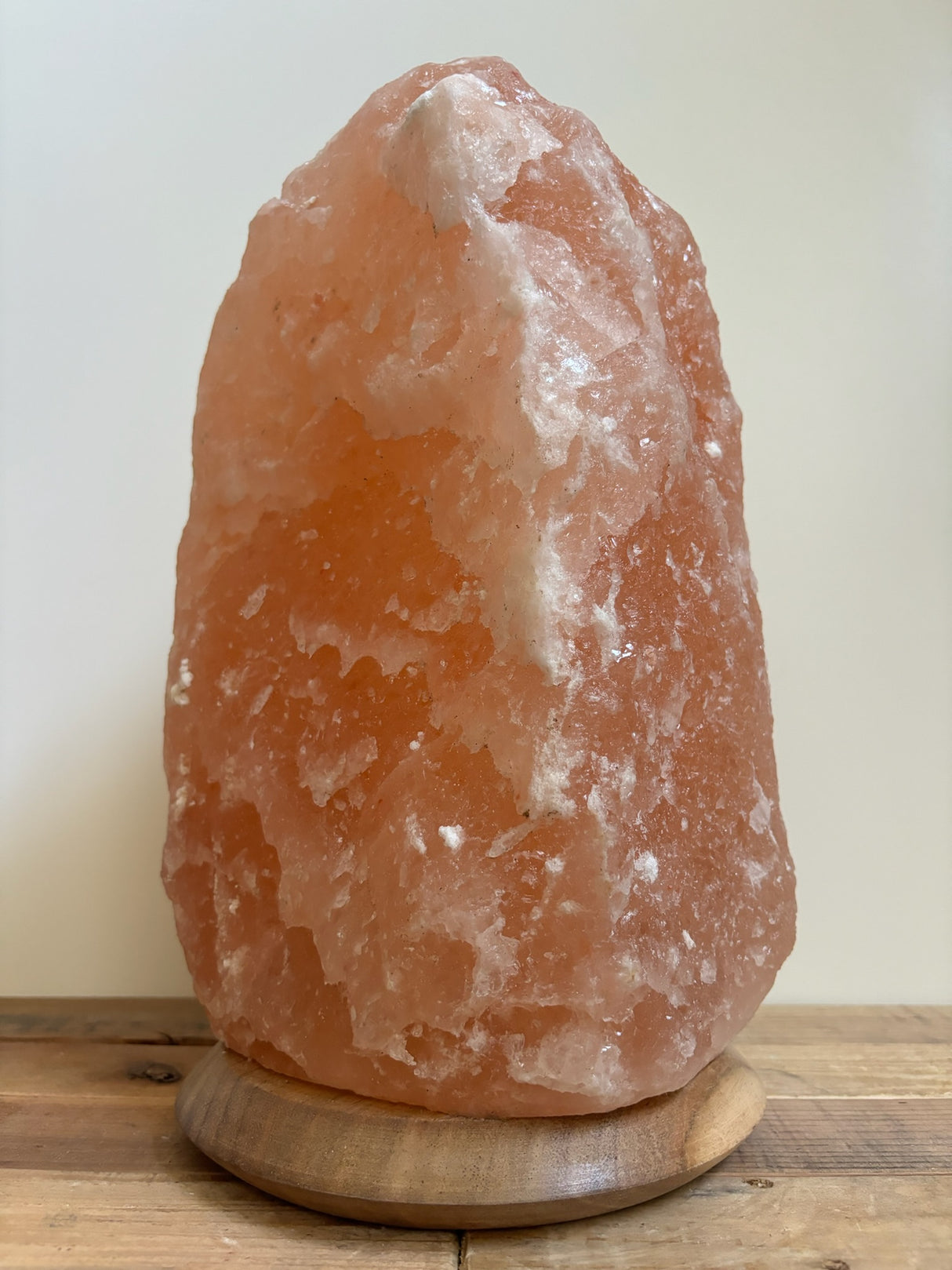 Himalaya zoutlamp 12-15kg, middelgroot formaat met warme, natuurlijke gloed, op stevige houten voet.