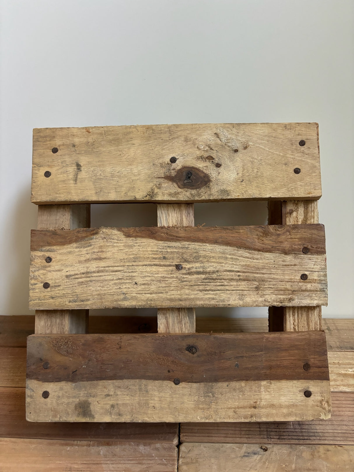 Vierkante houten pallet in warme houttinten met unieke nerftekening – ambachtelijk gemaakt en ideaal voor sfeervolle interieurstyling.