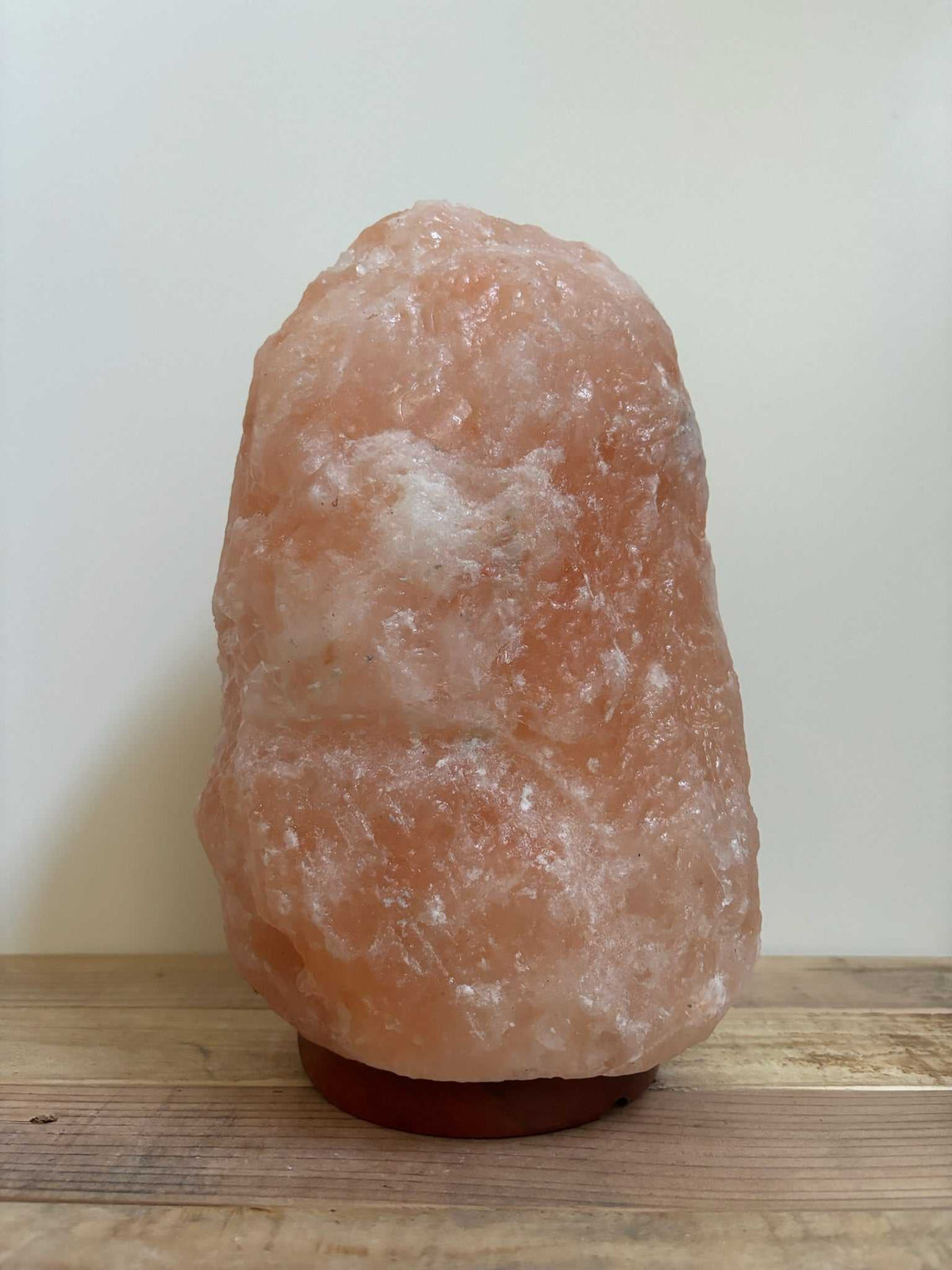 Himalaya zoutlamp op houten voet, veilig neergezet op een droge plek