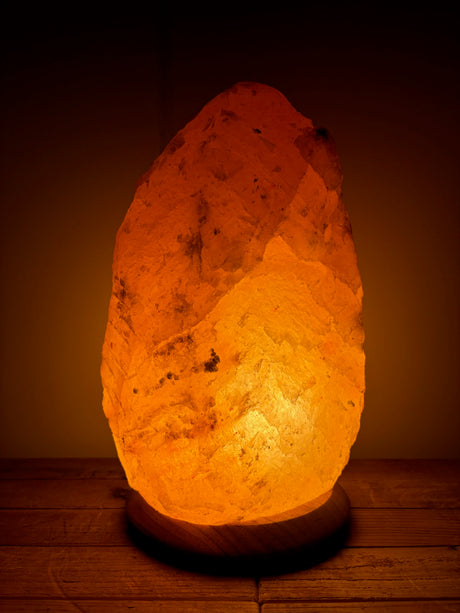Himalaya zoutlamp 12-15kg,middelgroot formaat met warme, natuurlijke gloed, op stevige houten voet.