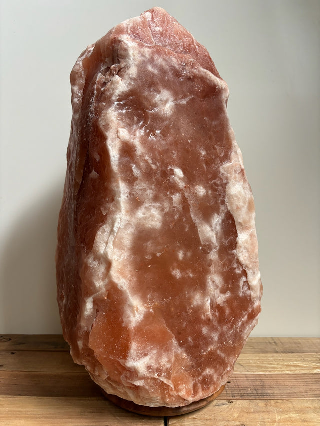 Grote Himalaya zoutlamp 30-35kg op houten voet, sfeervolle natuurlijke luchtzuiveraar voor woon- of bedrijfsruimte.