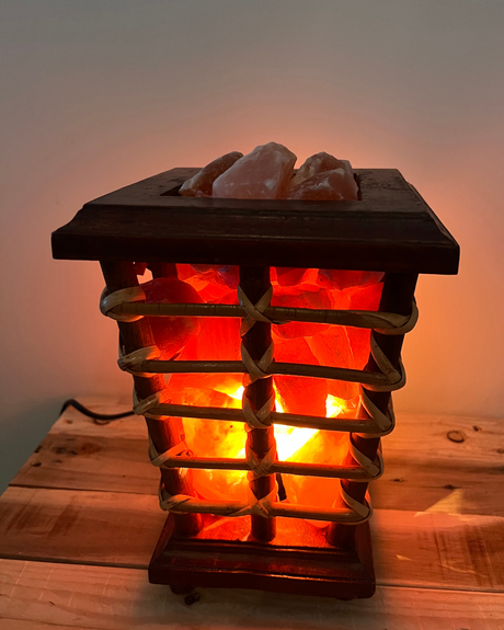 Trapeze mand van riet en hout gevuld met zoutsteenbrokken, inclusief lamp en kabel voor warme, sfeervolle verlichting.