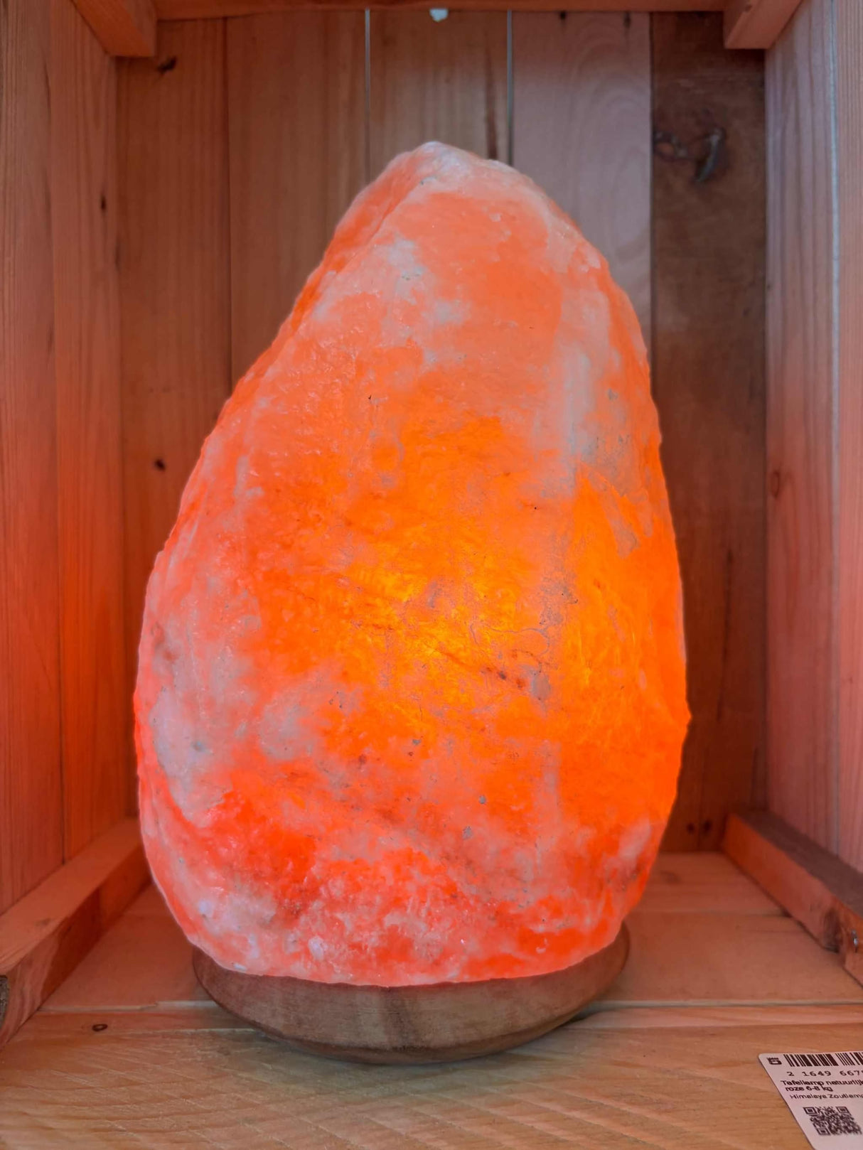 Himalaya zoutlamp van 6–8 kg met houten voet en warme amberkleurige gloed, handgemaakt van puur roze zout uit Pakistan