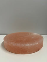 Ronde Himalaya zoutsteen kook- en serveerplaat van Ø20 cm, circa 4 kg. Natuurlijke roze steen geschikt voor warme bereidingen op BBQ of oven, en voor koude presentaties van sushi, kaas of desserts. Geeft gerechten een milde, subtiele zoutsmaak.