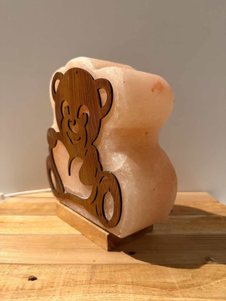 Handgemaakte Himalaya zoutlamp in de vorm van een beer met warm licht en houten voet.