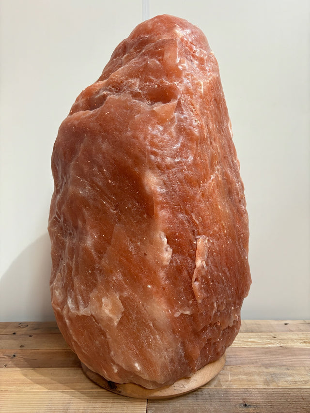 Donkere Himalaya zoutlamp 70–80 kg in rijke rood/oranje tinten op houten voet