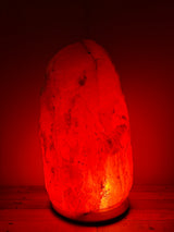 Lichte Himalaya zoutlamp 60–70 kg met warme gloed op stevige houten voet