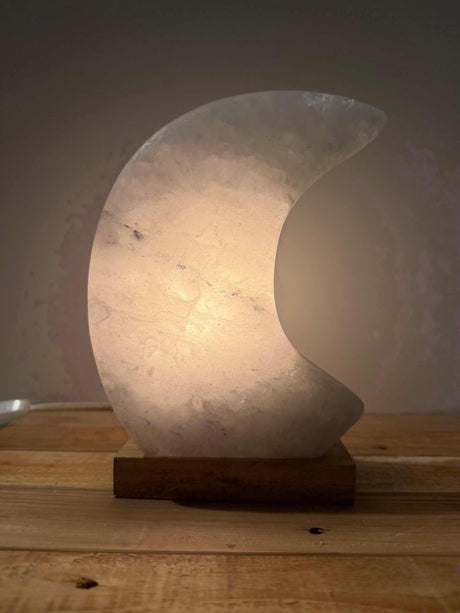 Handgemaakte maanvormige Himalaya zoutlamp in roze, grijs of wit met zachte, rustgevende gloed.