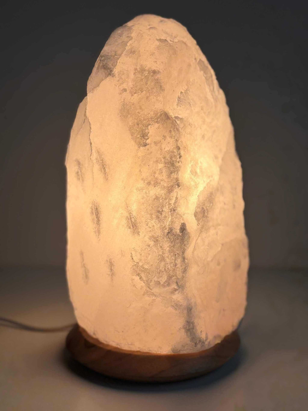 Witte Himalaya zoutlamp van 10-12 kg met houten voet, inclusief kabel en lampje, geschikt voor sfeervolle verlichting in huis.