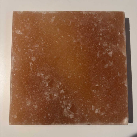 Massieve vierkante Himalaya zoutsteen tegel 20x20 cm met unieke kleurvariaties uit Khewra, ideaal als wandpaneel of sfeerverlichting.